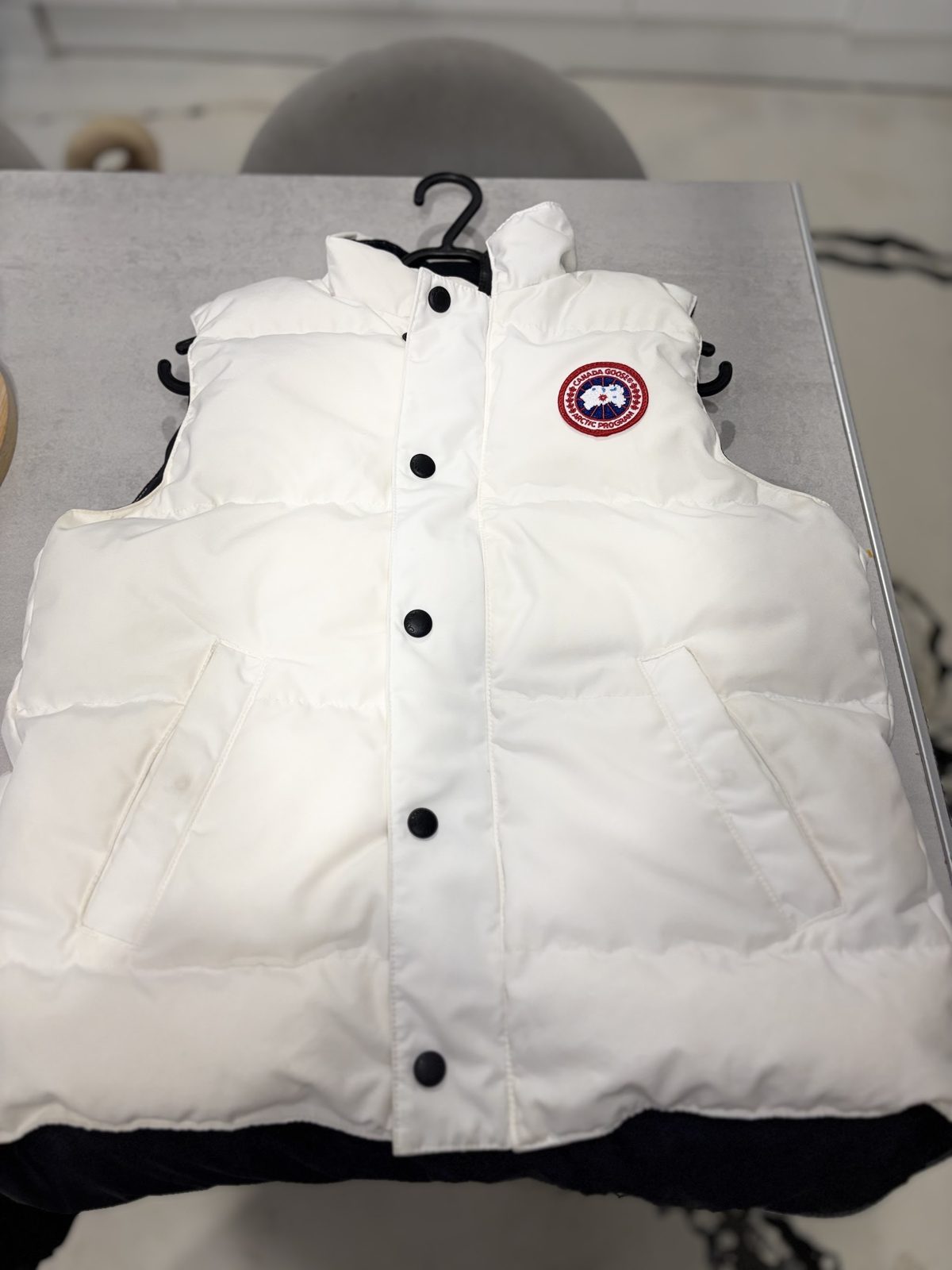 A white padded gilet, freshly cleaned and hung up