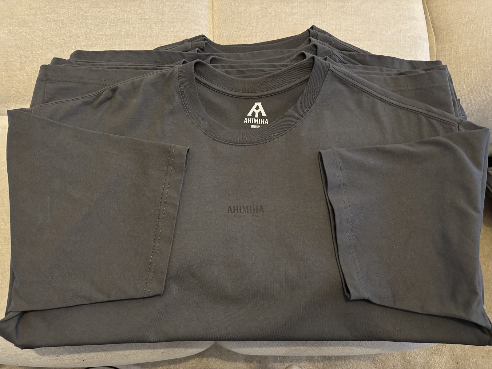 A neat pile of folded charcoal T-shirts